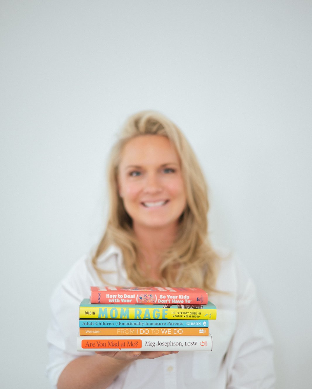 Caitlyn Skolnick with a stack of books — the New Jersey providers she trusts with her own clients