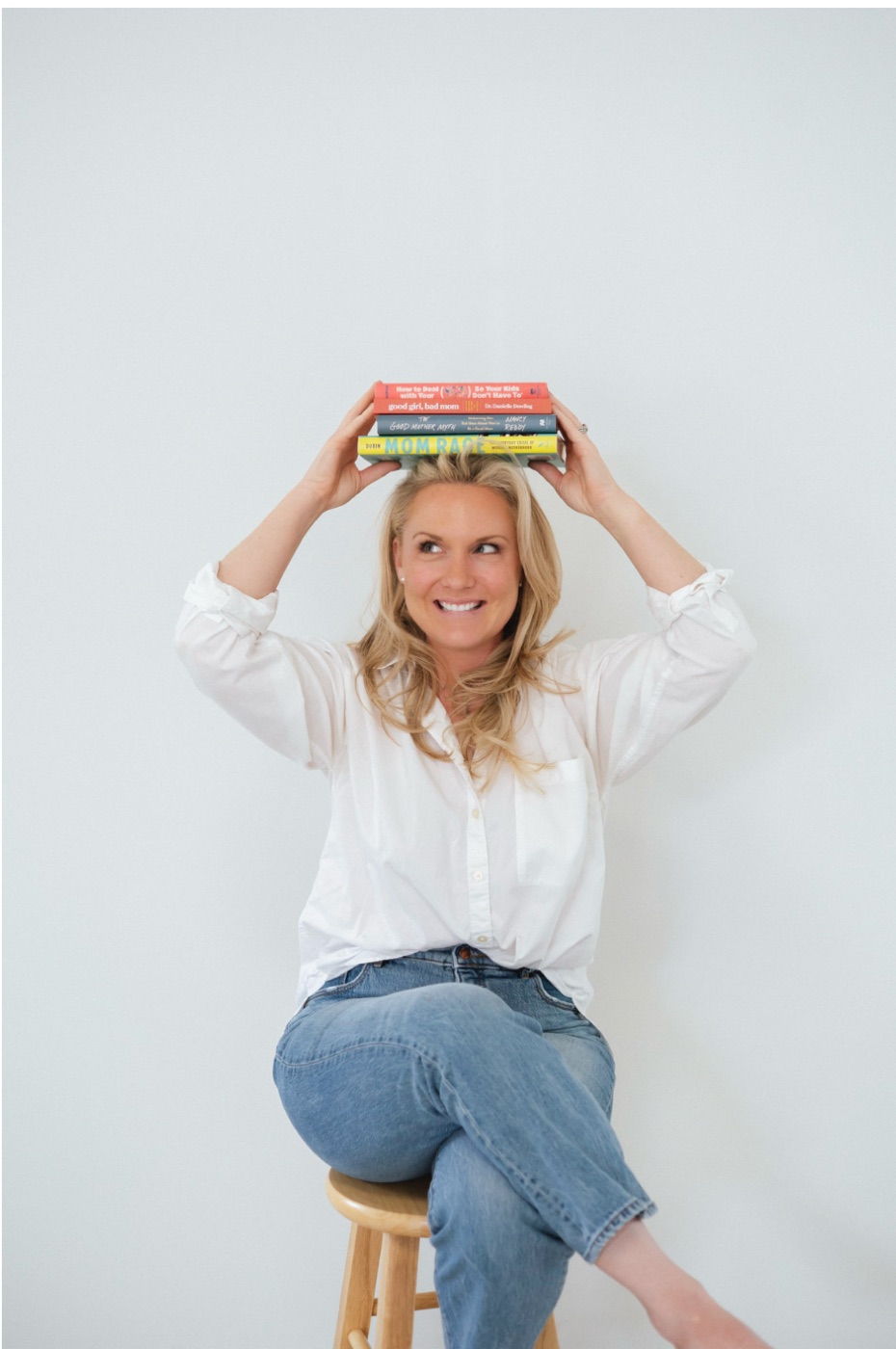 Caitlyn balancing a stack of parenting books on her head