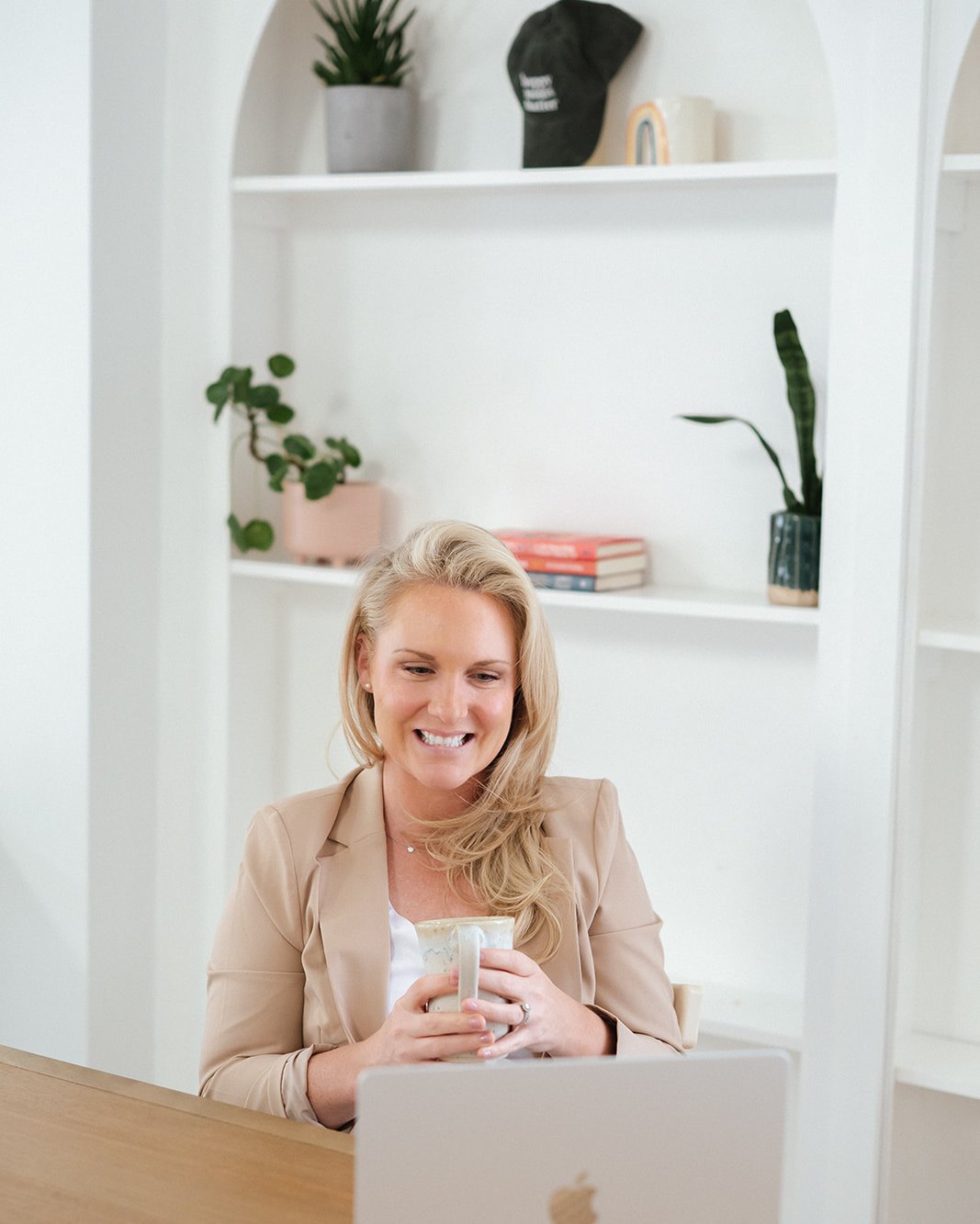 Caitlyn Skolnick, LCSW, PMH-C at her desk with a warm mug — perimenopause therapy in New Jersey