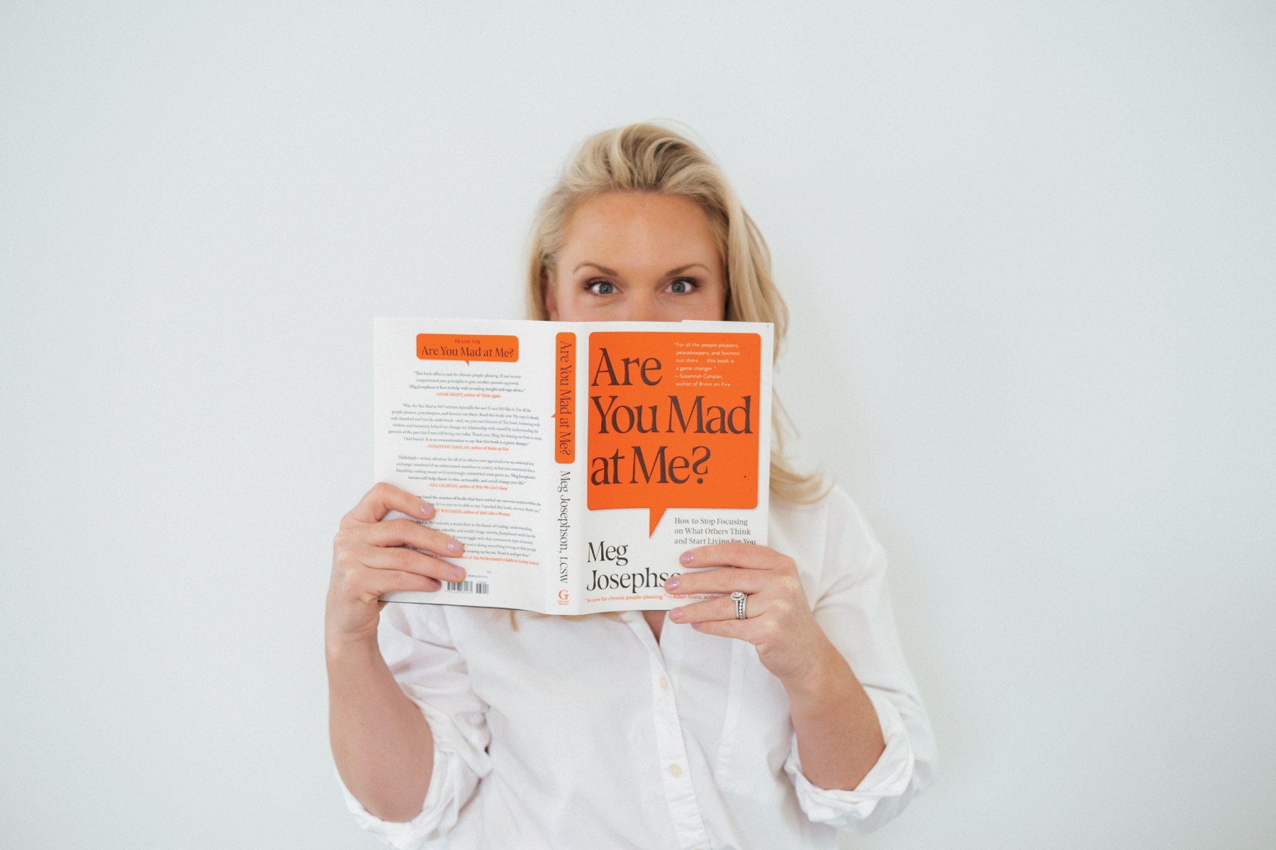 Caitlyn Skolnick holding a parenting book about children's big feelings