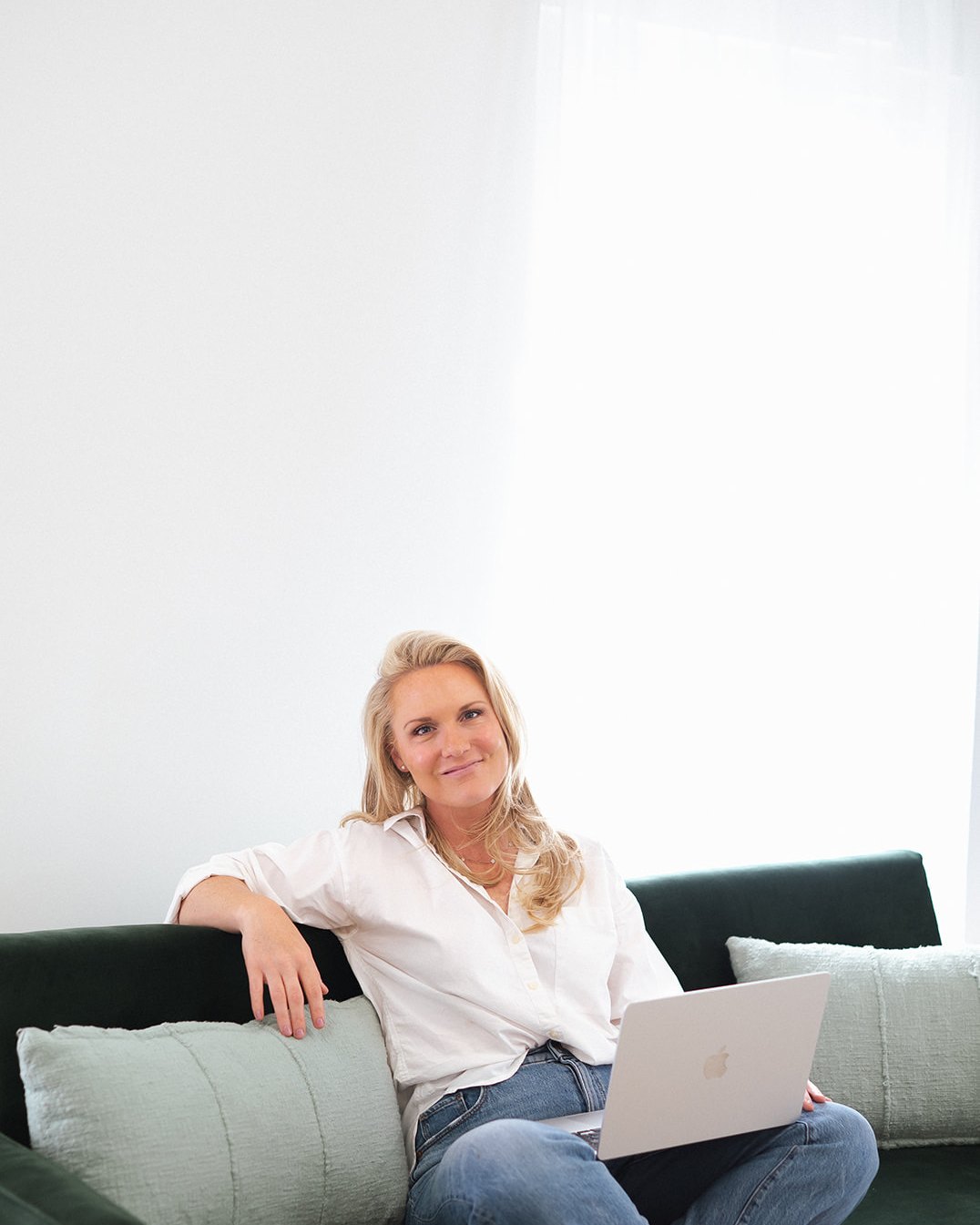 Caitlyn Skolnick cross-legged on the sofa — let's go find the woman underneath the roles